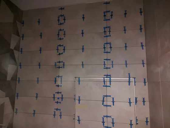 Falburkolás szintezőrendszerrel, geometriai dekorcsempe mellett